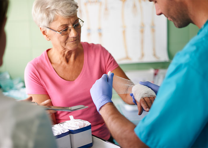 Image of nurse bandaging patients hand